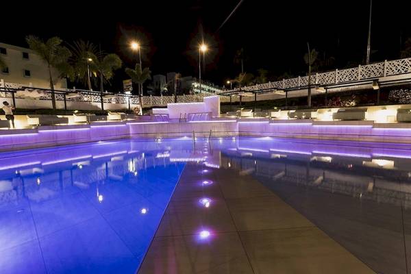 Pool des Caserio Hotels bei Nacht mit blauer Beleuchtung und Loungebereich