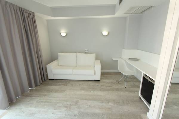 Ein modern eingerichteter Raum im Caserio Hotel mit einem weißen Sofa und einem Tisch.