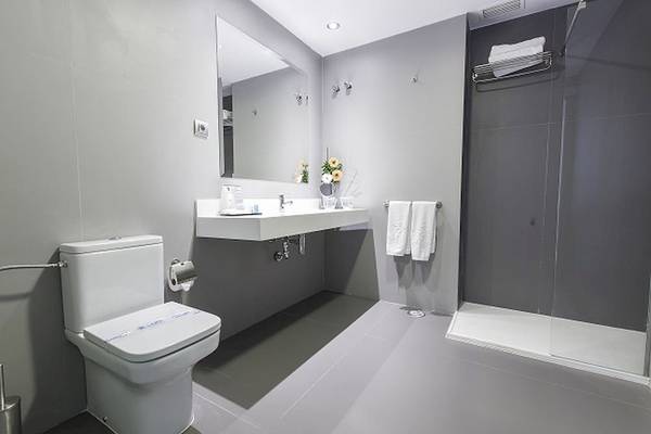 Badezimmer im Caserio Hotel mit Toilette, Waschbecken und Dusche