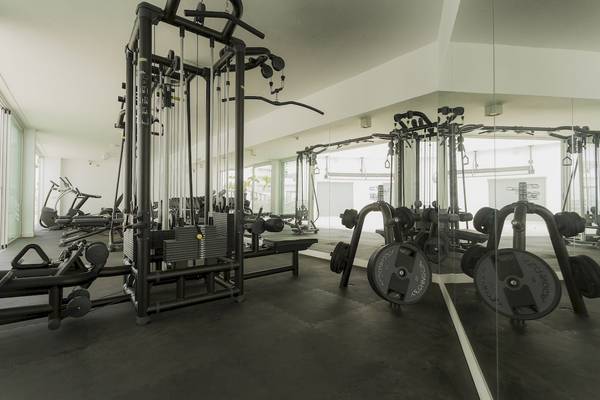 Innenansicht des Fitnesscenters im Caserio Hotel mit verschiedenen Trainingsgeräten und Geräten.