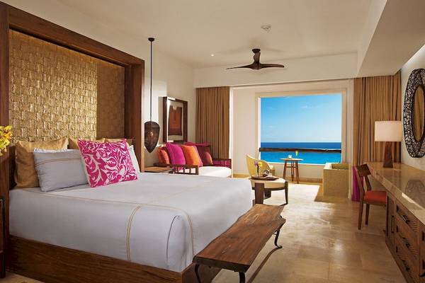 Luxuriöses Zimmer mit Meerblick im Secrets Akumal Riviera Maya Hotel mit Kingsize-Bett, Blick auf das Meer und modernem Design.