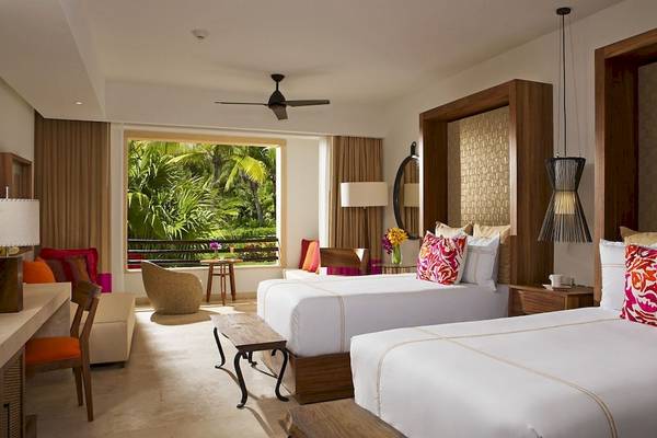 Suite im Secrets Akumal Riviera Maya Hotel mit zwei Betten, Balkon und tropischer Aussicht