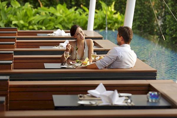 Paar genießt Mahlzeit im Holiday Inn Mai Khao Resort neben dem Pool