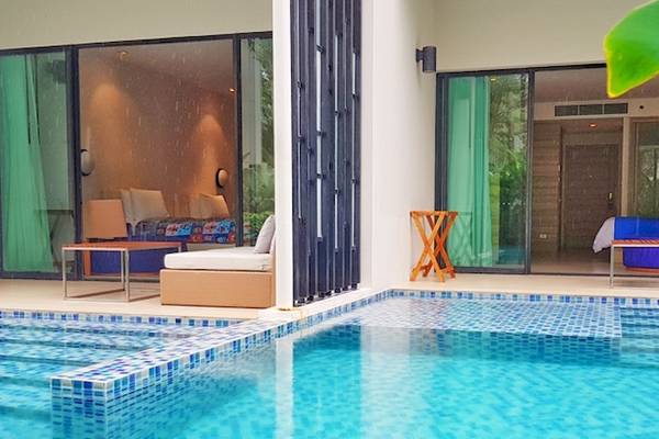 Außenbereich des Holiday Inn Mai Khao Resorts mit Swimmingpool und Loungebereichen.