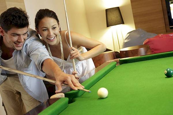 Ein Paar spielt Billard im Hotel Holiday Inn Mai Khao Resort.