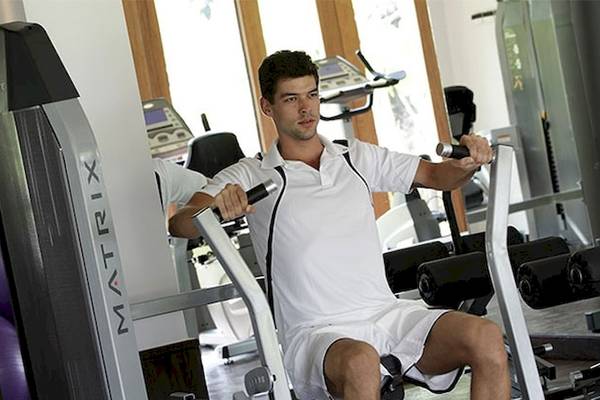 Ein Mann trainiert im Fitnessstudio des Holiday Inn Mai Khao Resort.