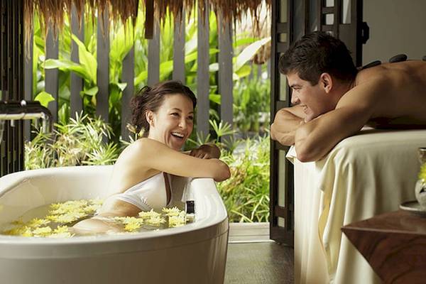 Paar genießt Spa-Behandlung im Holiday Inn Mai Khao Resort, Frau in Badewanne mit Blumen, Mann auf Liege