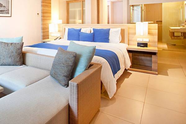 Schlafzimmer im Holiday Inn Mai Khao Resort mit Bett, Couch, Tisch und Fernseher