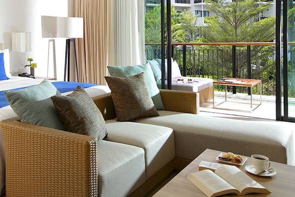 Ferienwohnung im Holiday Inn Mai Khao Resort mit großem Bett, Sofa, Balkon und Aussicht auf Bäume