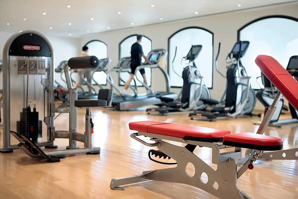 Fitnessstudio im Cove Rotana Resort mit Laufbändern und Hantelbank.