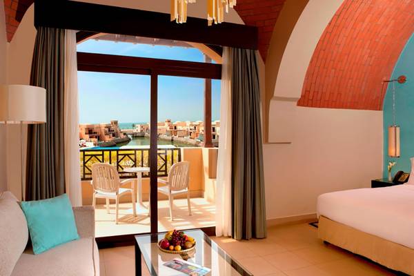 Suite im Cove Rotana Resort mit Balkon und Blick auf den Hafen.