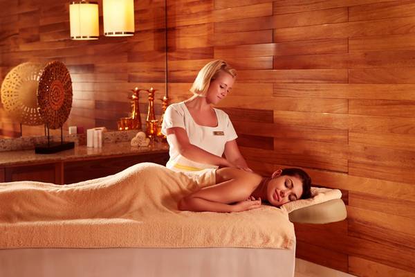 Eine Frau genießt eine Massage im The Cove Rotana Resort Spa.