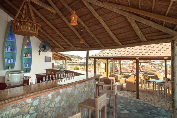 Außenbereich eines Hotels mit Bar, Sitzen und Bar-Tresen, Blick auf die Strandpromenade.