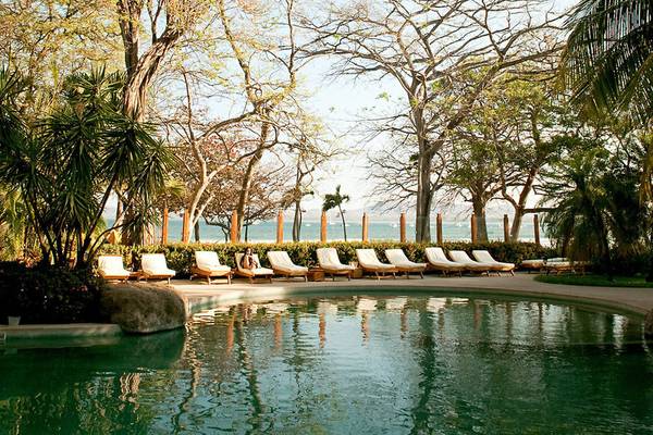 Schwimmbad mit Liegestühlen und Meerblick im Capitan Suizo Beachfront Boutique Hotel