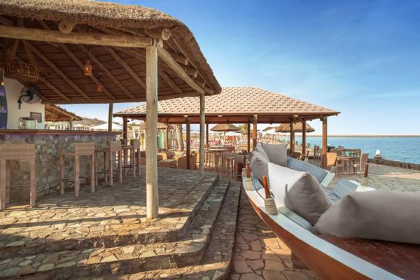 Strandbar des Cove Rotana Resorts mit Lounge-Sesseln und Meerblick