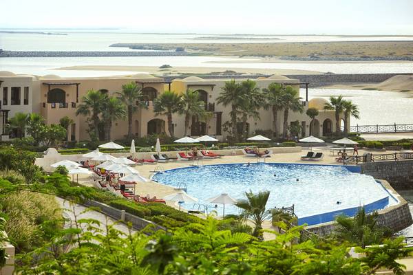 Das Cove Rotana Resort mit Blick auf den Poolbereich und das Meer.