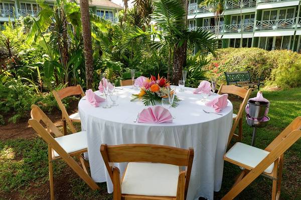 Hochzeitstisch im Freien im Couples Negril Hotel mit weißen Tischdecken und Blumendekoration.