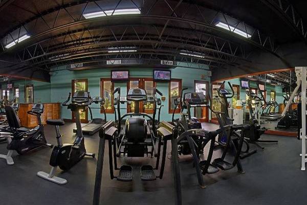 Fitnessstudio im Couples Negril Hotel mit verschiedenen Trainingsgeräten.