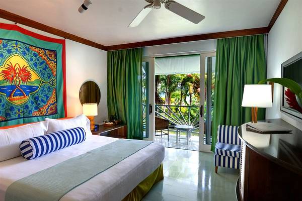 Zimmer im Couples Negril Hotel mit Blick auf den Balkon und das Meer.