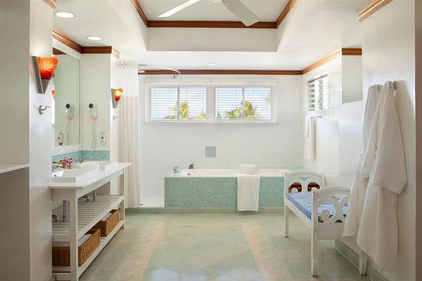 Das Badezimmer des Couples Negril Hotels mit Badewanne, Waschbecken und Fenstern.