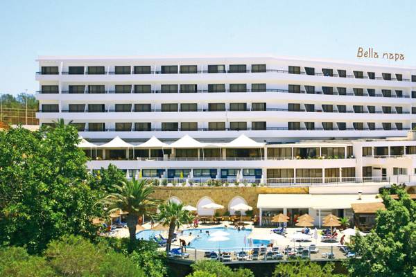 Außenansicht des Bella Napa Bay Hotels mit Swimmingpool und Sonnenschirmen.