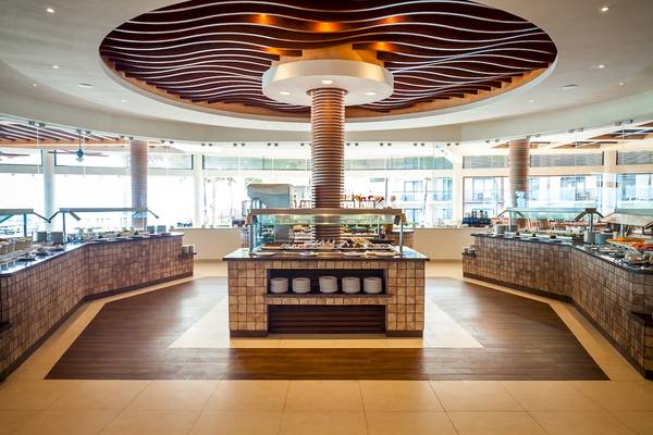 Buffetbereich im Reef Coco Beach Hotel mit vielen Gerichten und modernen Holzböden.