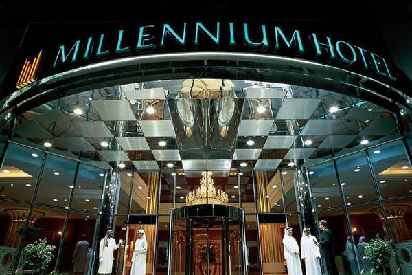 Corniche Hotel Abu Dhabi mit Eingangsbereich, Kristallleuchte und Personen, die draußen stehen.