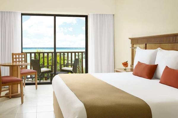 Zimmer im Reef Coco Beach Hotel mit Blick auf den Balkon und das Meer.