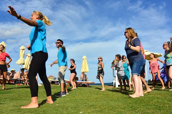 Gruppe von Menschen, die einen Aerobic-Kurs auf dem Rasen des Kiani Beach Resorts abhalten
