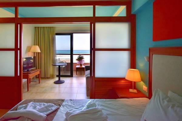 Zimmer im Kiani Beach Resort mit Blick auf das Meer und ein geräumiges Bett.