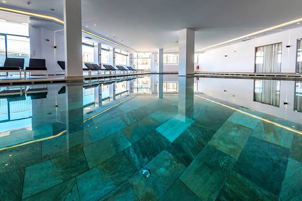 Ein großer Swimmingpool mit blauen Fliesen im Kiani Beach Resort
