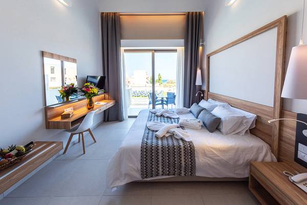 Schlafzimmer im Kiani Beach Resort mit Blick auf die Terrasse und das Meer.