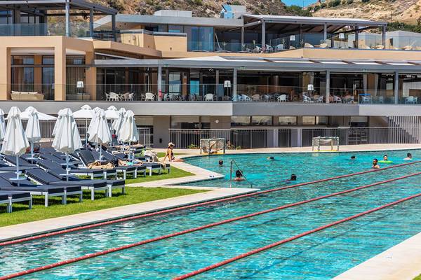 Außenpoolbereich des Kiani Beach Resorts mit Liegestühlen und Gästen.