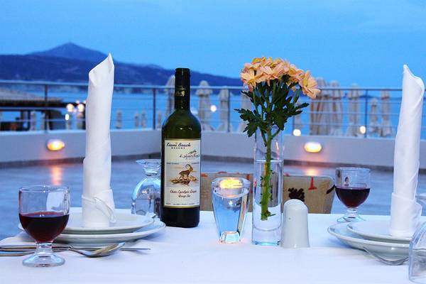 Terrasse des Kiani Beach Resort mit Tisch und Blumenvase