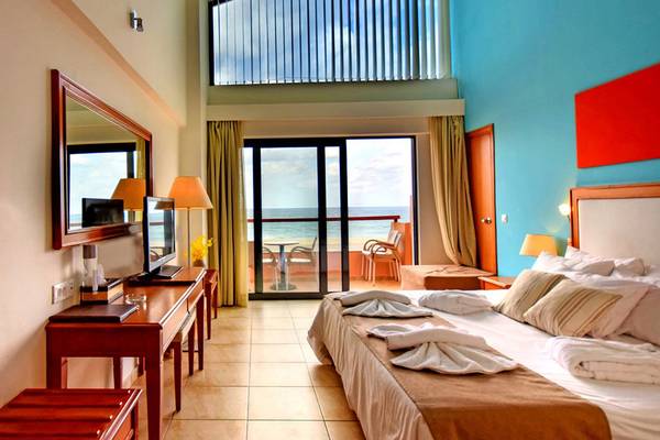 Hotelzimmer im Kiani Beach Resort mit Blick auf das Meer und Möbel auf der Terrasse.