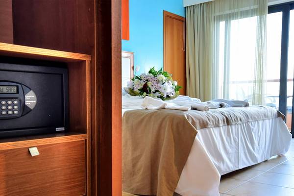 Ein Hotelzimmer mit einem Safe im Schrank und einem Bett mit Blumen.
