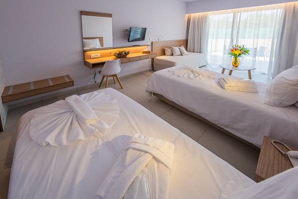 Hotelzimmer im Kiani Beach Resort mit zwei Betten, Schreibtisch und Fernseher.