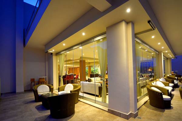 Außenbereich des Kiani Beach Resort mit Möbeln und Glaswänden