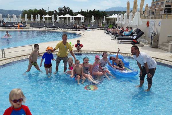 Gruppe von Kindern und Erwachsenen, die Spaß im Pool des Kiani Beach Resorts haben.