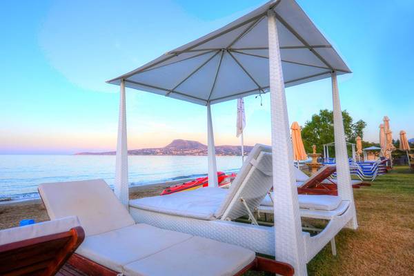 Strandliegen im Kiani Beach Resort mit Blick auf das Meer und die Berge.