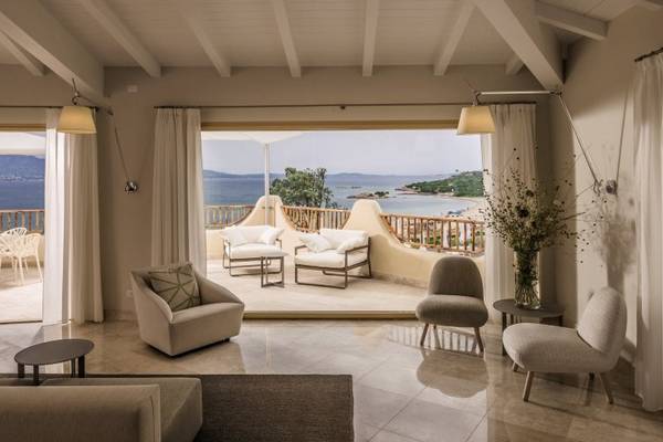 Wohnbereich im Cala Cuncheddi Hotel mit Blick auf das Meer und die Berge.