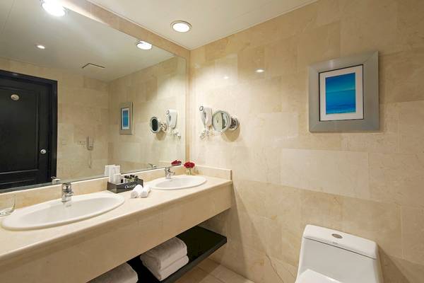 Badezimmer im Ocean Blue & Sand by H10 Hotel mit zwei Waschbecken, Spiegel und Toilette.