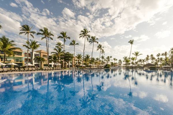 Außenpool des Ocean Blue & Sand by H10 Hotels mit Palmen und Sonnenliegen