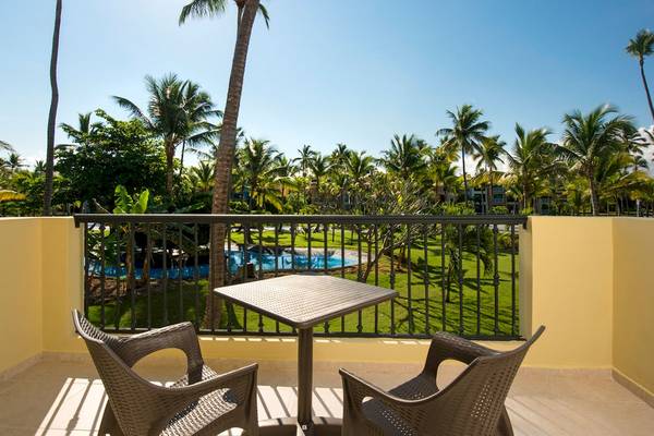 Ein Balkon mit Tisch und Blick auf einen Pool im Ocean Blue & Sand by H10 Hotel.