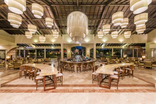 Lobby des Ocean Blue & Sand by H10 Hotels mit Bar, Tischen und Stühlen.