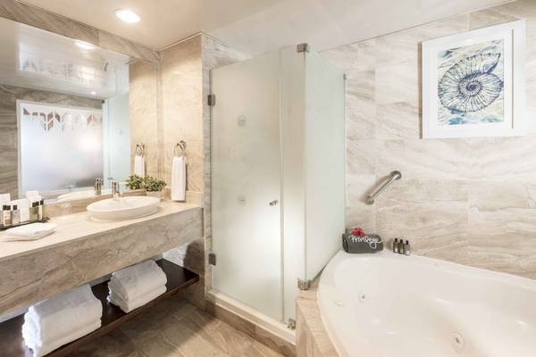 Badezimmer im Ocean Blue & Sand by H10 mit Badewanne, Dusche und Waschbecken.