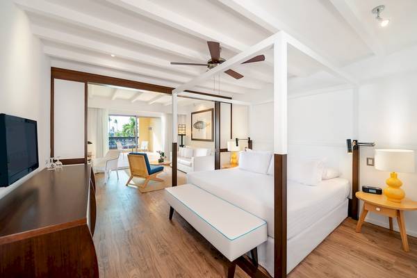 Innenansicht eines Zimmers im Ocean Blue & Sand by H10 Hotel mit einem Bett, Möbeln und Fernseher.