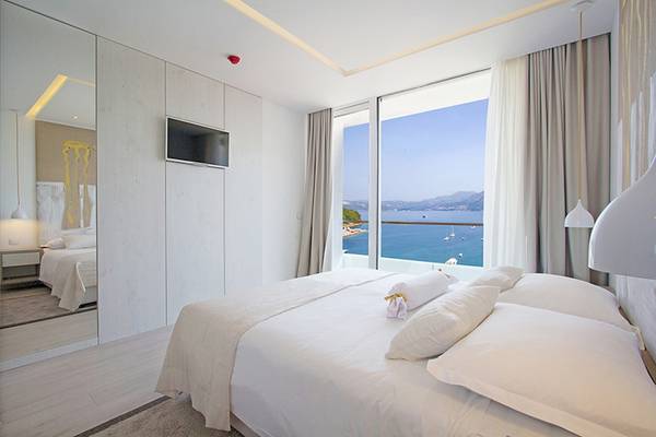 Zimmer mit Meerblick im Cavtat Hotel mit Bett, Fenster und Aussicht auf das Meer.