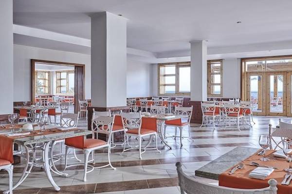 Innenansicht des Restaurants im Solymar Reef Marsa Hotel mit vielen Tischen und Stühlen, Meerblick.