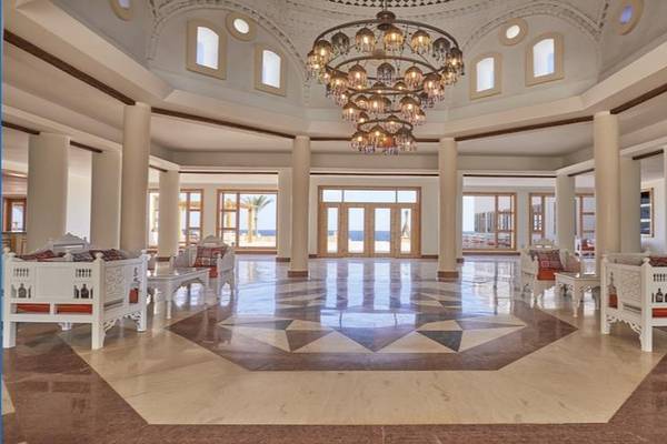 Lobby des JAZ Neo Reef Marsa Almaz Hotel mit weißen Möbeln und einem großen Kronleuchter